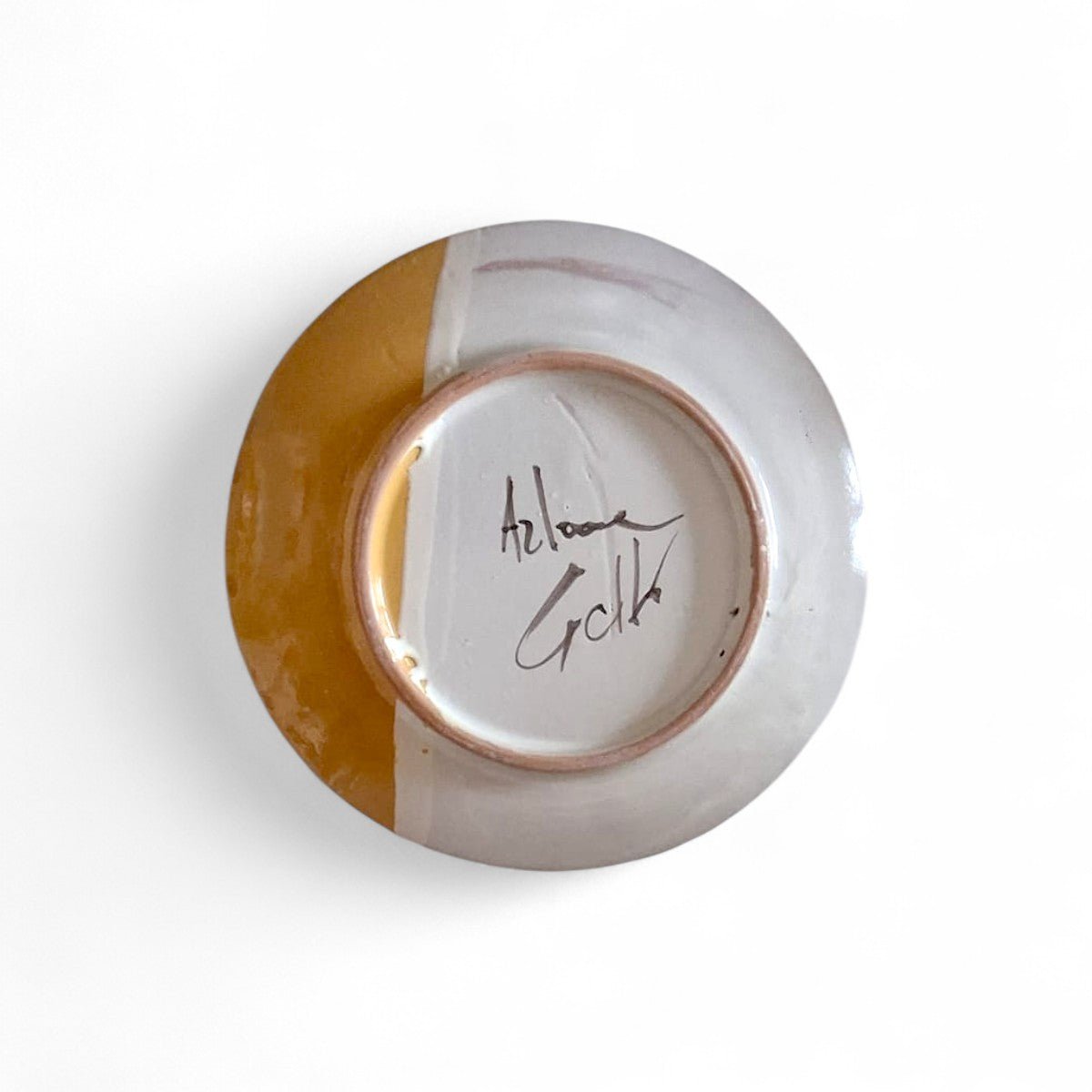 La firma dell'artista Artema Galli sul retro del piatto maiolica dipinto.