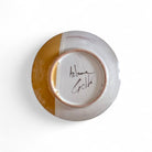 La firma dell'artista Artema Galli sul retro del piatto maiolica dipinto.