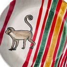 Dettaglio del fondo dinamico con strisce diagonali rosse, verdi e ocra del piatto.