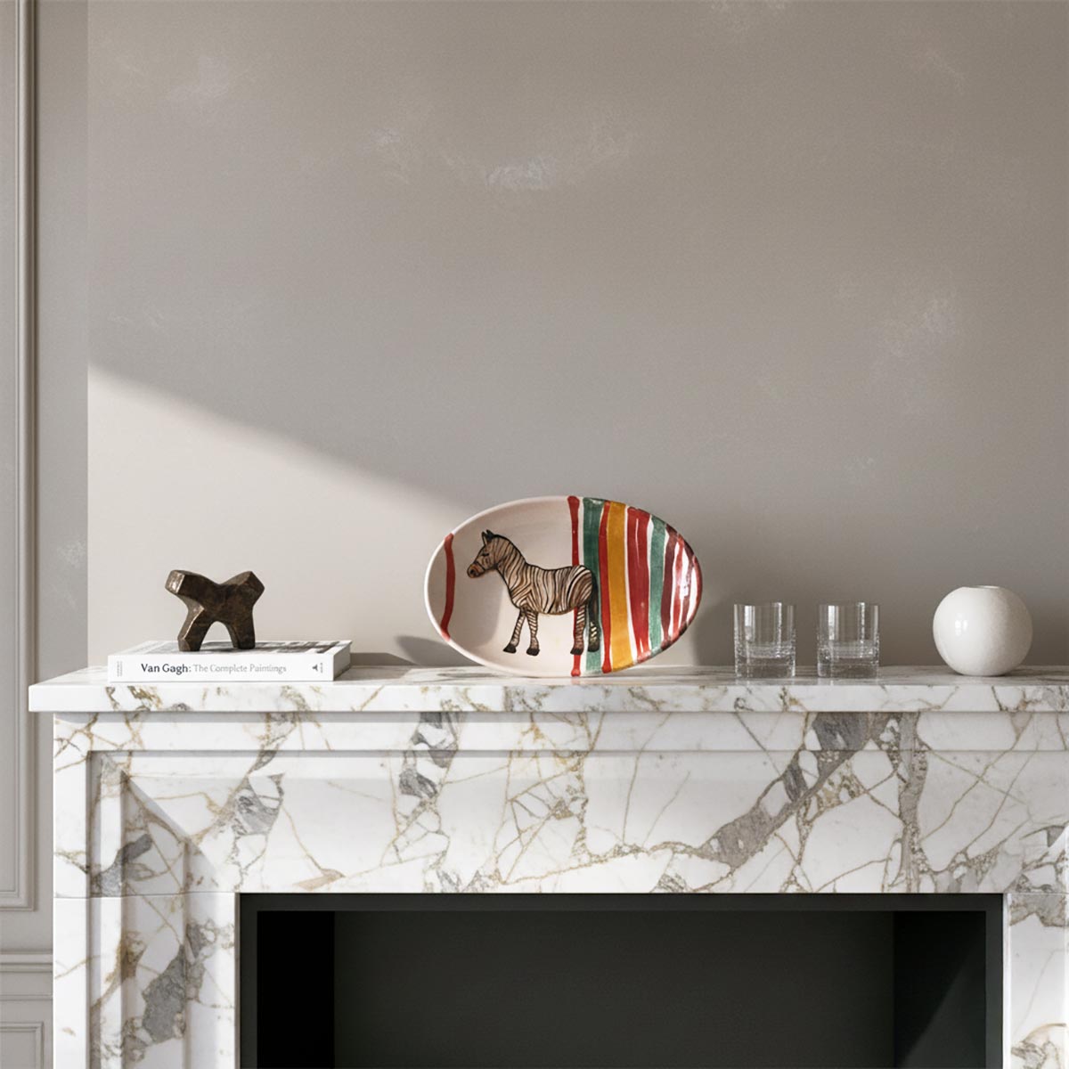 Il piatto Zebra Iconica esposto come scultura scultoreo su un camino in marmo.