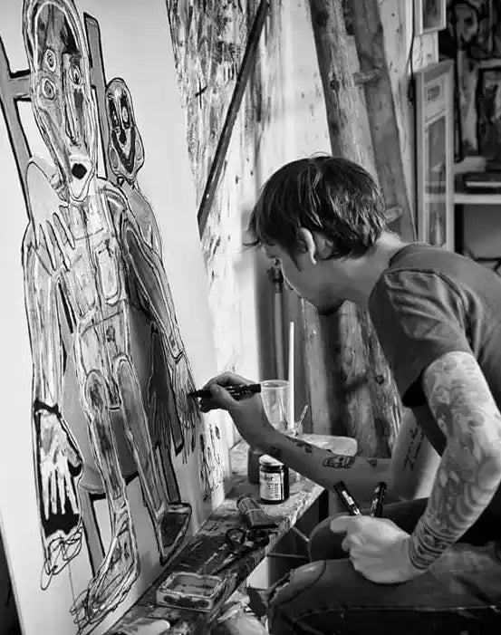 foto in bianco e nero dell'artista massimiliano precisi che dipinge un quadro nel suo studio per la collezione vicode