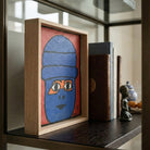 Dipinto naive marocchino di un volto blu in cornice di okoume su scaffale.