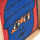 Particolare del copricapo blu e dello sfondo rosso scuro del quadro.