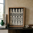 Quadro monocromatico di arte grafica marocchina Mabchour con cornice in legno naturale.