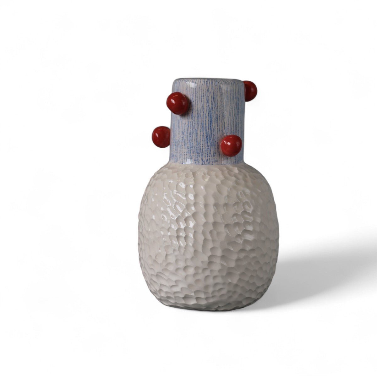 Profilo del vaso in ceramica rosso che ne mostra la forma scultorea e le sfere in rilievo.