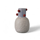 Profilo del vaso in ceramica rosso che ne mostra la forma scultorea e le sfere in rilievo.