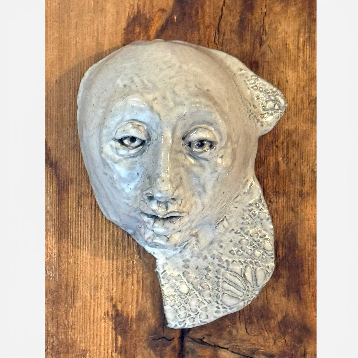 Scultura materica Frammento d'Anima installata su parete in resina bianca.