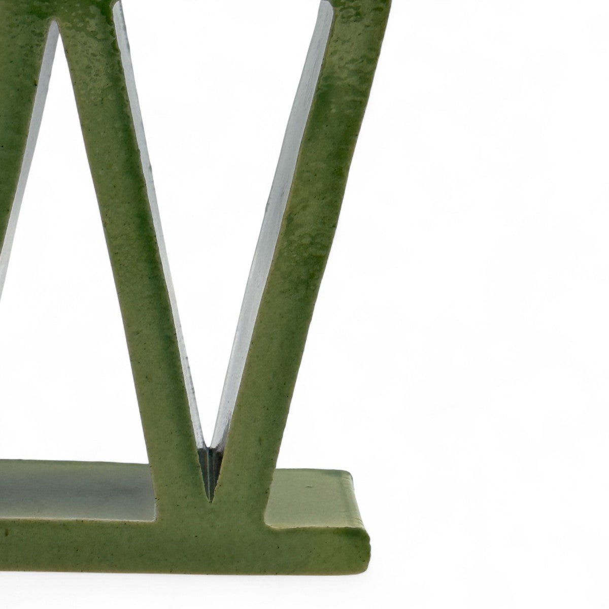 Dettaglio della struttura a pieni e vuoti triangolari della scultura in ceramica verde.