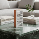 La scultura in terracotta bianca Alba Inclinata esposta su una scrivania di design.