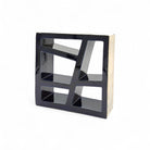 Vista di tre quarti della scultura in terracotta blu, che mostra il gioco di pieni e vuoti.