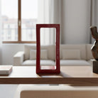 La scultura in terracotta rossa Passaggio Rubino esposta su una mensola, che incornicia un oggetto.