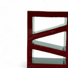 Primo piano dello smalto vermiglio denso e passionale sulla scultura in terracotta rossa.