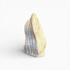 Scultura Vicode posizionata su un piano in pietra naturale per un effetto materico.