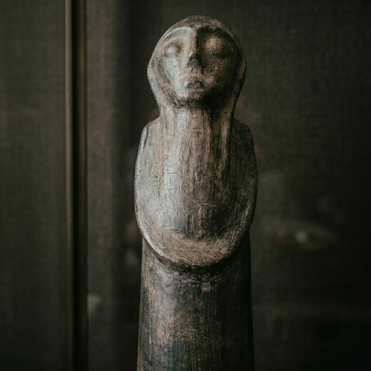 Braccia conserte modellate a rilievo che cingono il corpo cilindrico della statua decorativa di Sejnane.