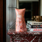 Scultura in ceramica calligrafica con sfumature rosa e segni grafici neri.