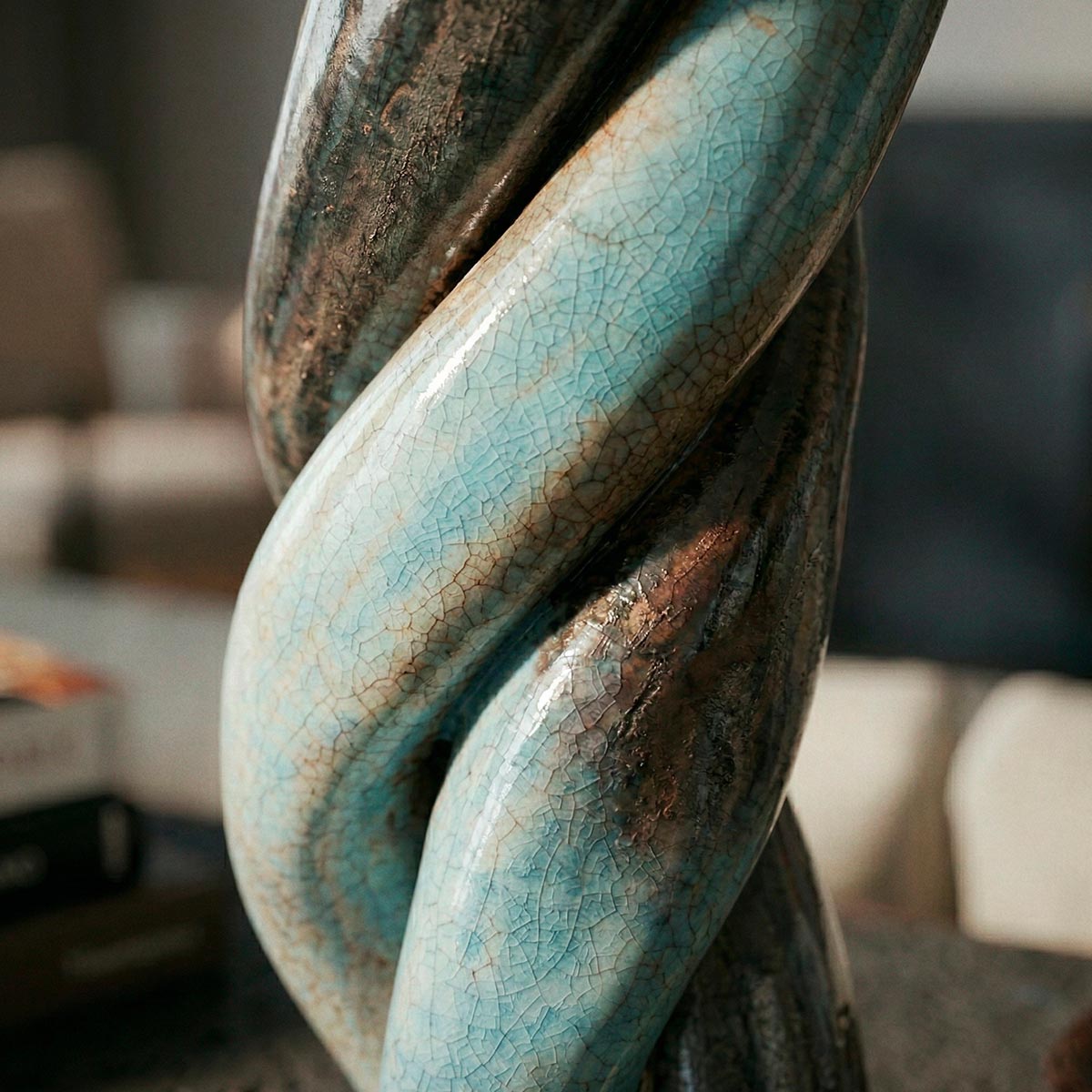 Scultura organica in ceramica raku con forma a tripla elica intrecciata.