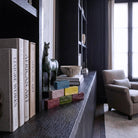 Le cinque Sculture dei Sensi disposte a piramide su unalibreria in legno scuro