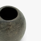 dettaglio del Vaso sferico nero su superficie bianca.