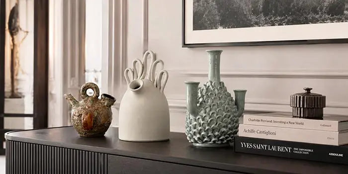 composizione di vasi di diverse misure e colori su credenza di design in living