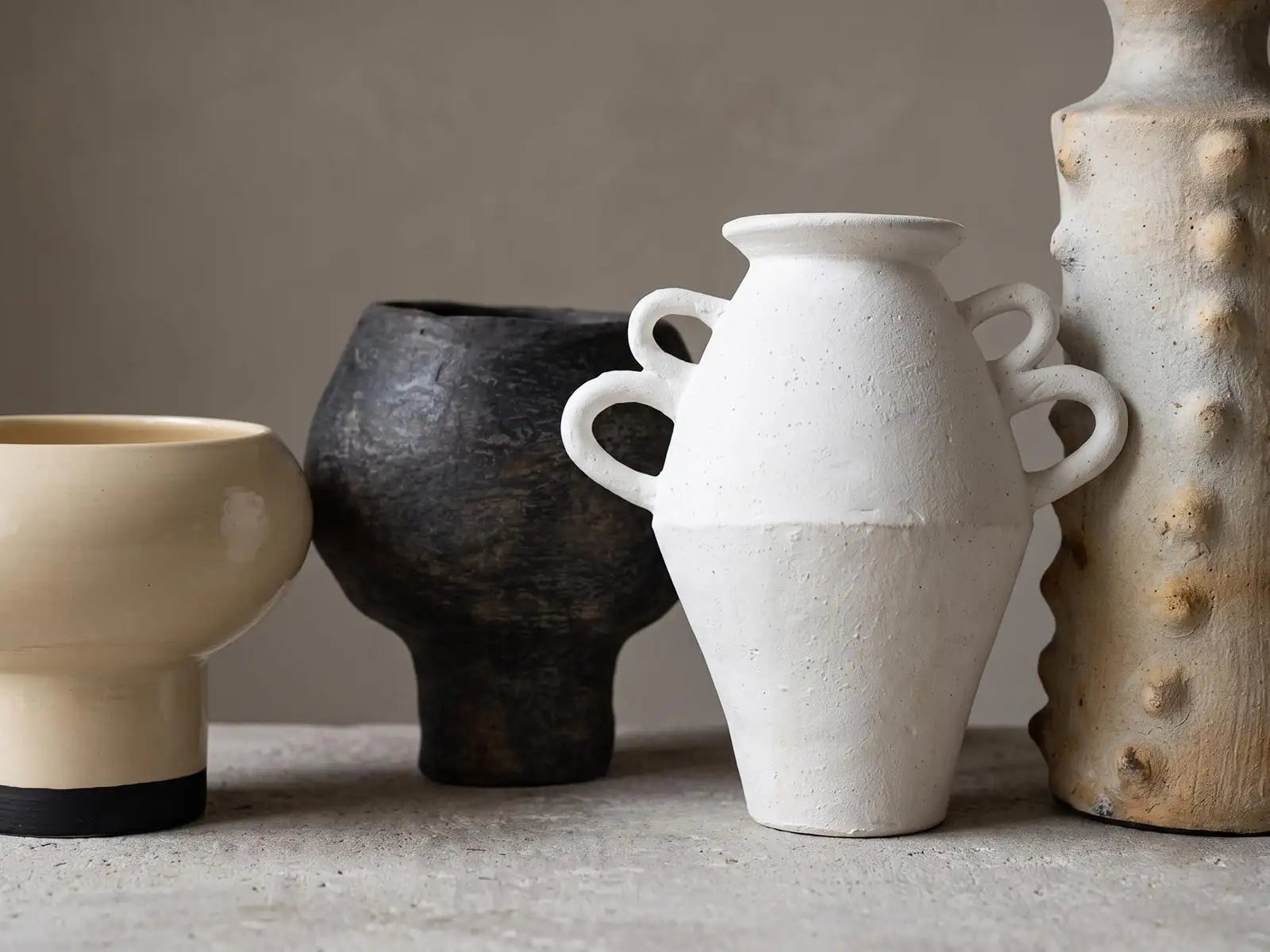 vasi di diversa tipologia di ceramica, smaltata, materica, texturizzata, cotta nel fuoco, colori avorio, bianco e nero