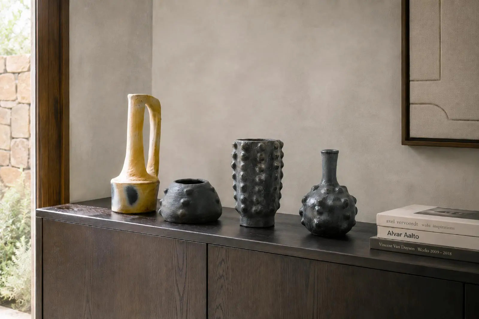Vasi Malles in ceramica nera selezionati da Vicode in un interno elegante con libri d’arte