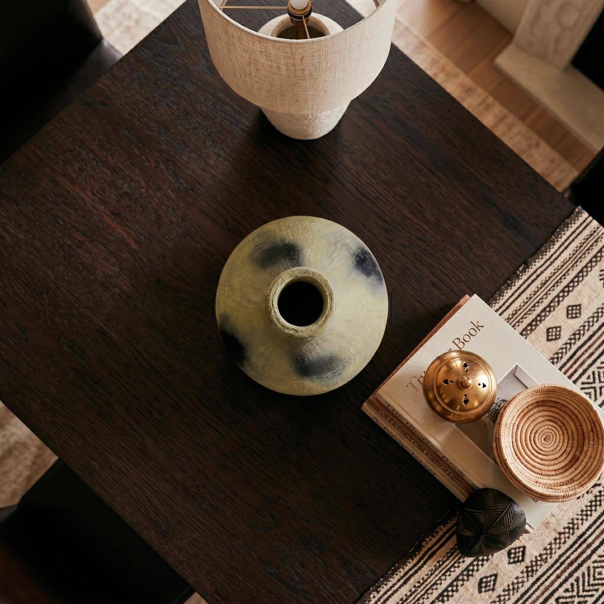 Dettaglio del forte contrasto tra le macchie di fumo nero e l'argilla color sabbia del vaso scultoreo.