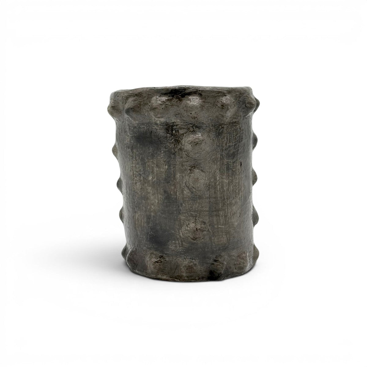 Primo piano dei rilievi verticali che creano un gioco d'ombre materico sulla superficie del vaso d'arte.