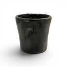 Il vaso conico di Habiba esposto come accento di design d'avanguardia sopra un tavolo in marmo scuro.