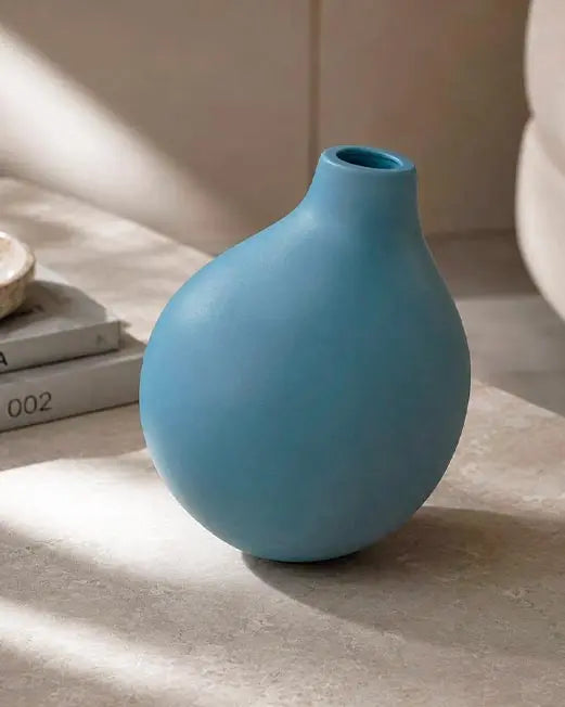 vaso di design in ceramica color carta da zucchero sopra tavolino in un living moderno