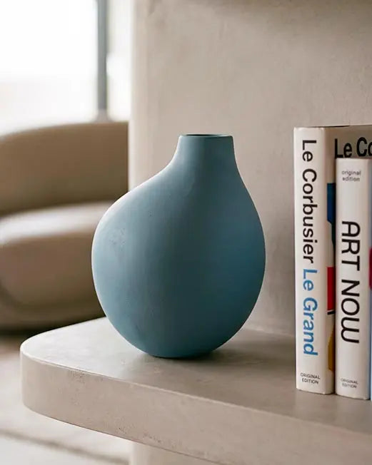 vaso di design in ceramica color carta da zucchero sopra tavolino in un living moderno