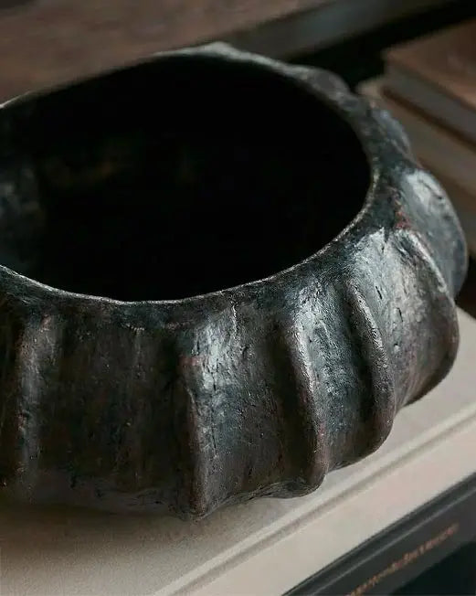 vaso di design scultoreo nero in una libreria moderna