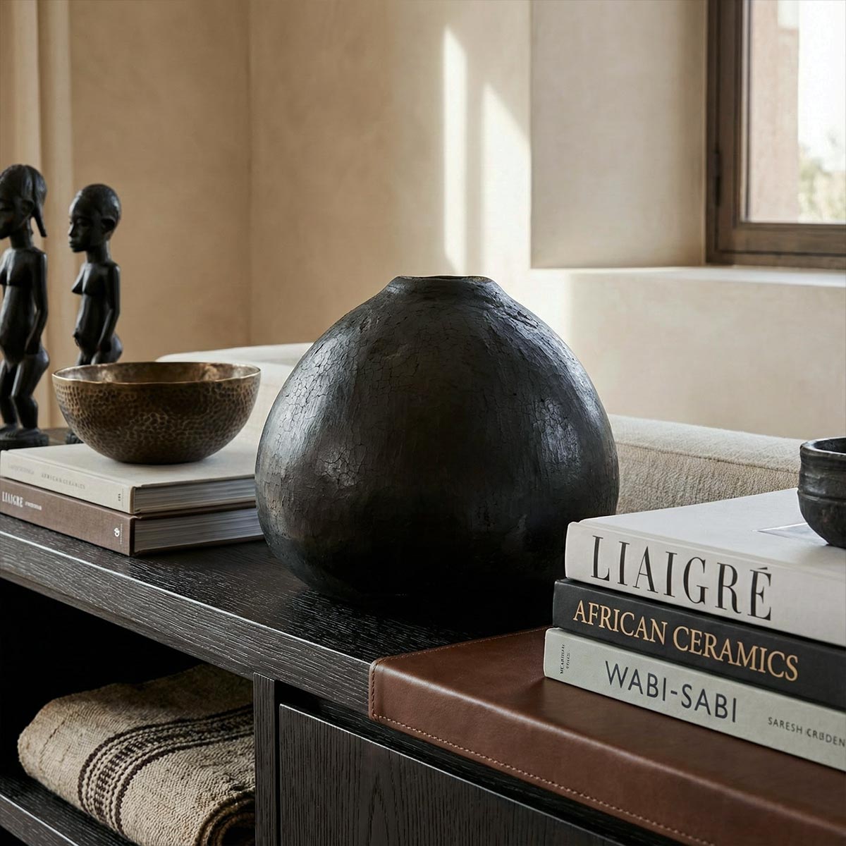 Vaso goccia nero lucido ambientato in un salotto minimalista di design