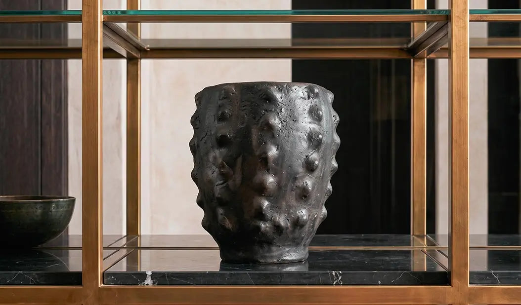 vaso di design mallesx vicode su libreria in marmo nero e ottone