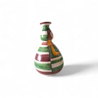 Il vaso pupetta maiolica accanto a una tazza per un confronto dimensionale.