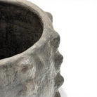 La firma dell'artista Hanene incisa sulla base della scultura in argilla cruda.