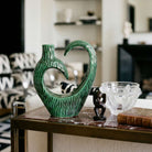 Vaso scultoreo verde con forma astratta curva e texture incisa