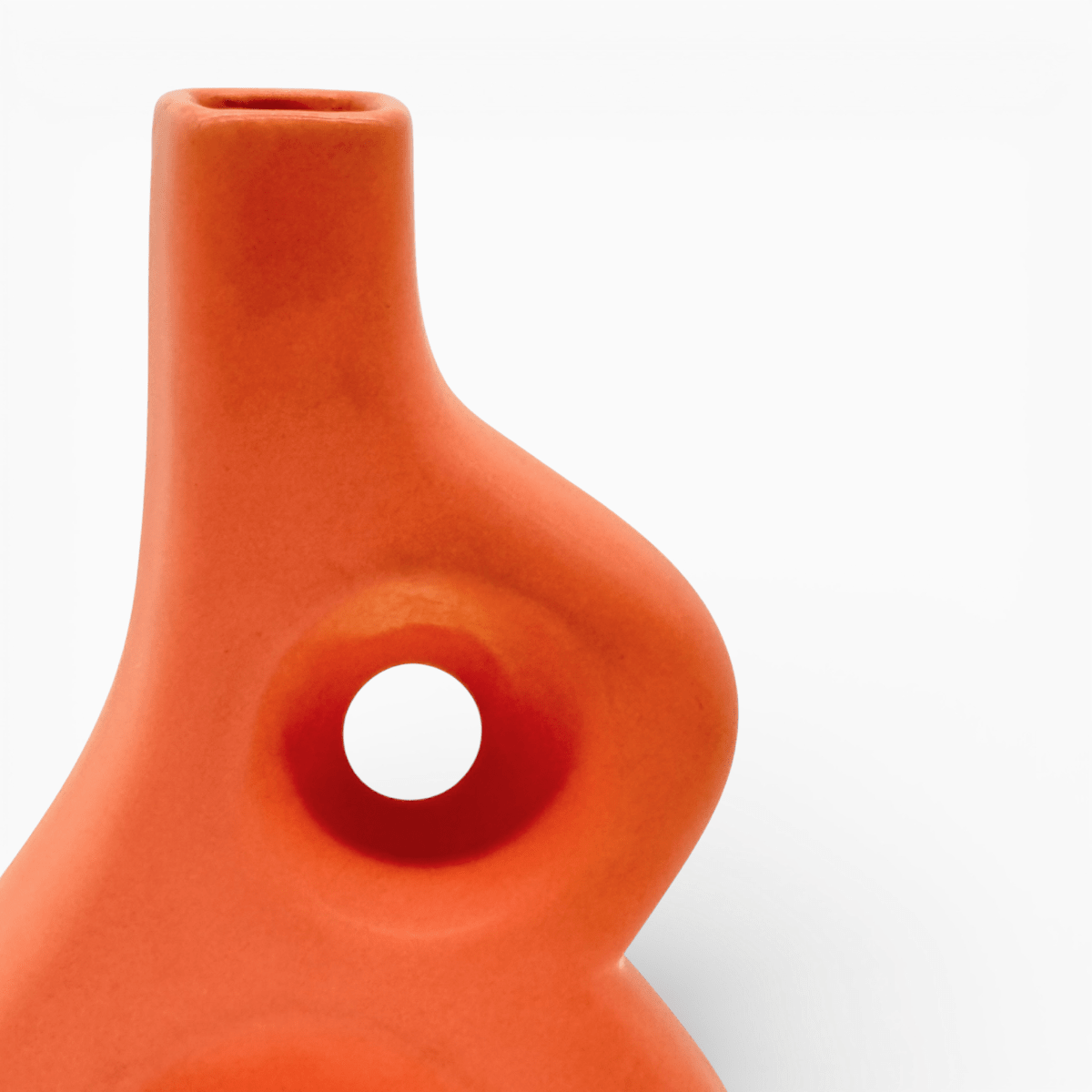 Vaso artistico arancione forma astratta curva su sfondo bianco