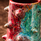 Dettaglio collo vaso con protuberanze e smalto rosso cremisi