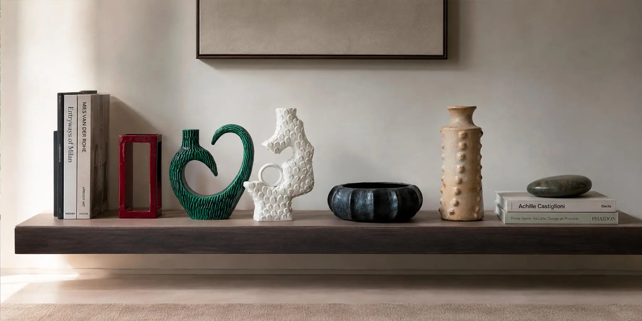 collezione di vasi vicode di design su mensola in legno scuro rivestita in pelle
