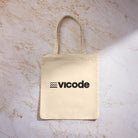 Tote bag in cotone Vicode con logo nero stampato su tessuto color naturale.